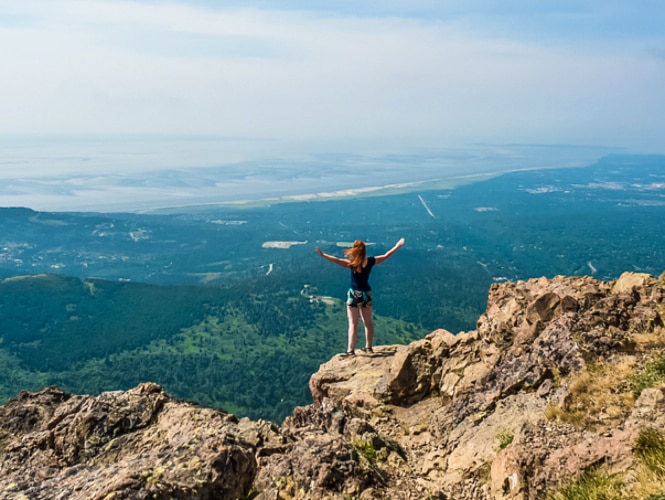 A woman enjoying the view from the edge of Flattop Mountain