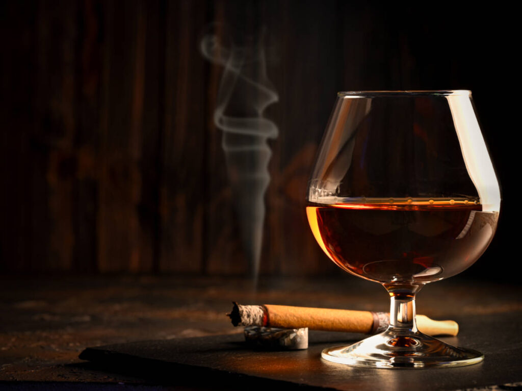Glass of rum and a cigar on the table