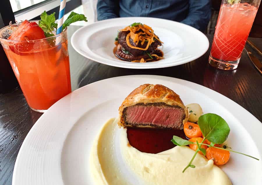 Beef dish with mashed potatoes and two glasses of cocktail drinks at Gordon Ramsay's Hell’s Kitchen in Las Vegas