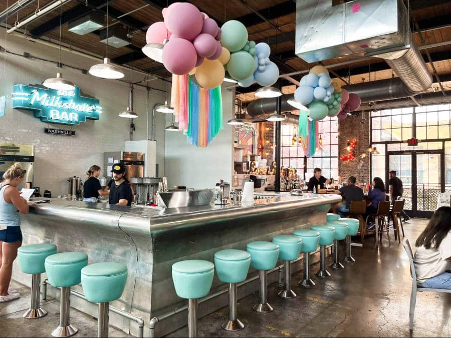 A dreamy interior of tiffany blue bar stools hung pastel balloons, and tussles in The Milkshake Bar in Nashville