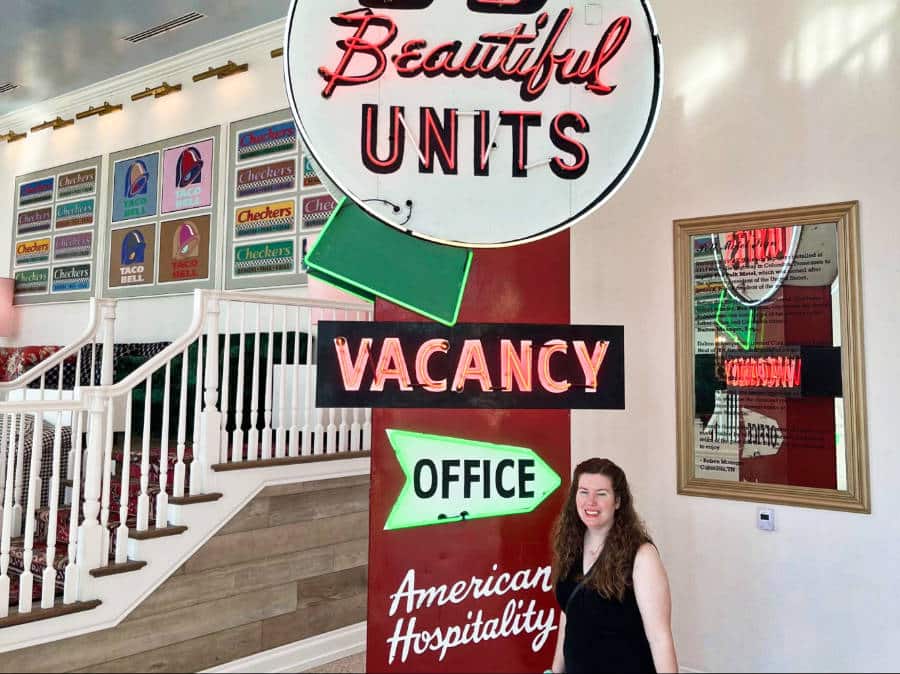 The author Elizabeth posing near the neon signages of Graduate Hotel lobby