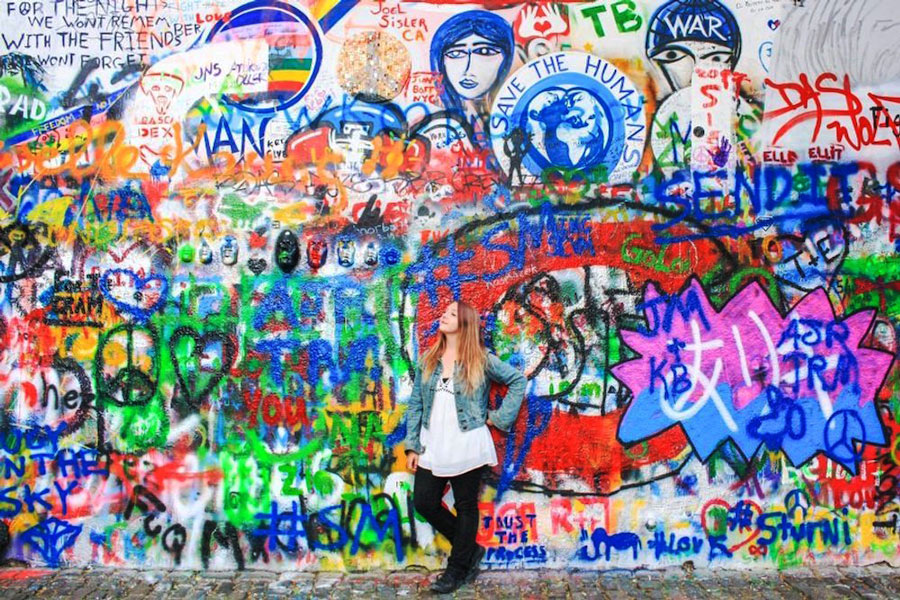 The author posing for a picture in front of a graffiti wall