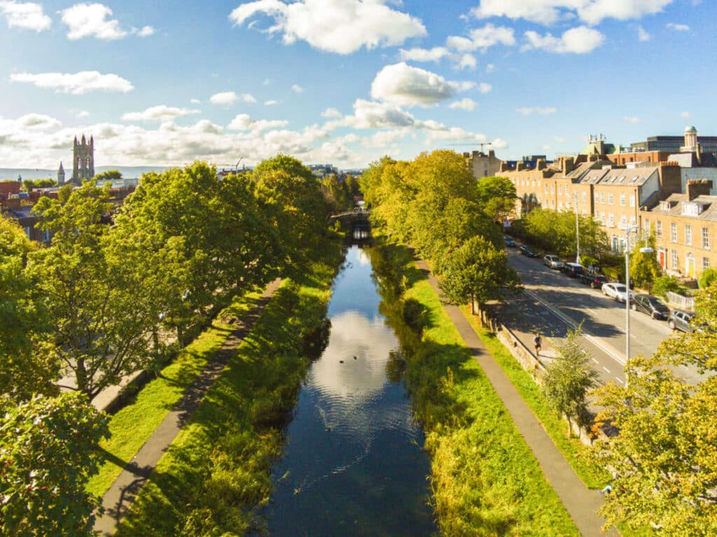 Aerial view of the grand canal surrounded by lush greenery in Portobello on a sunny day