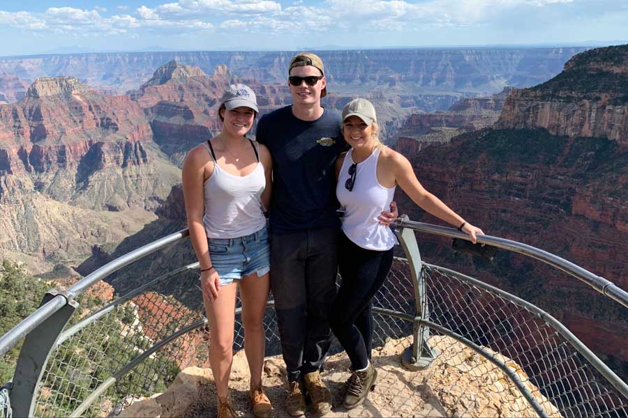 The author with her brother and his fiancé at the lookout point of Grand Canyon National Park