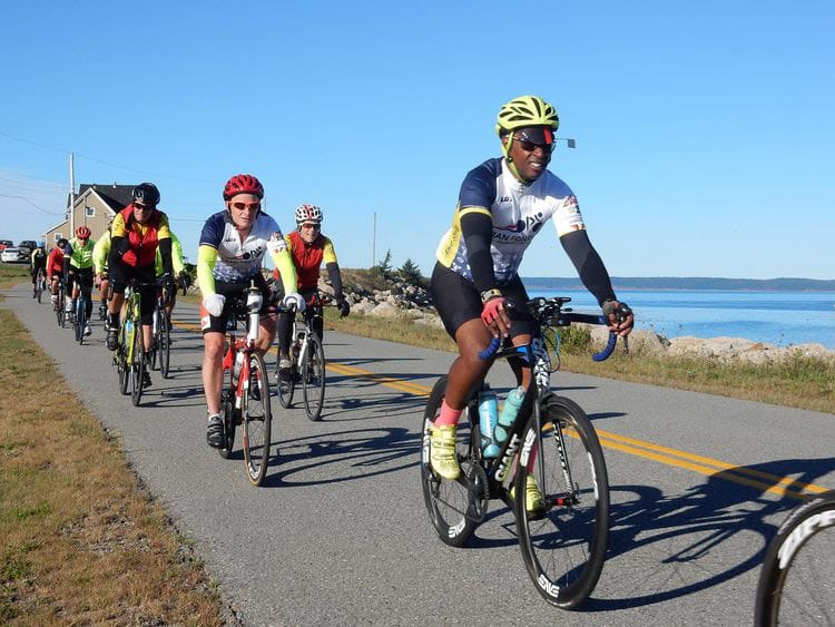 People riding a bike on coastal road