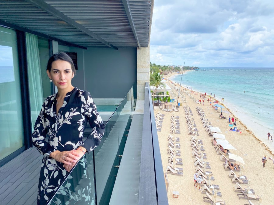 Clara on a balcony with the view of the beach