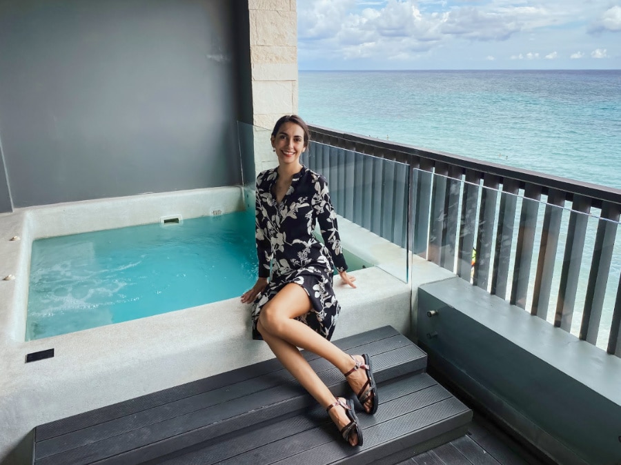 Clara sitting on the edge of a jacuzzi in a balcony