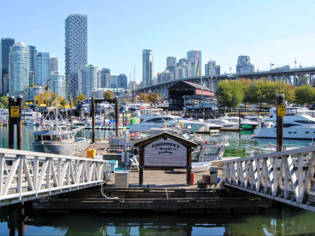 A picturesque view of Vancouver's city skyline with boats at a dock