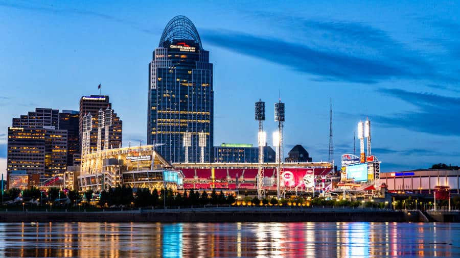 View of the illuminated Great American Building towering over the Cincinnati skyline from across the Ohio River at dusk