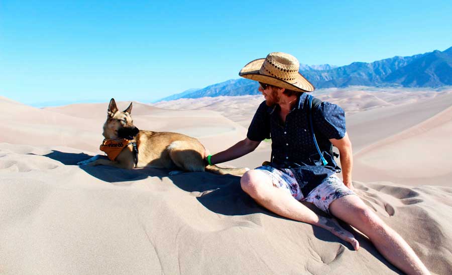 The author's husband with their dog in Great Sand Dunes National Park