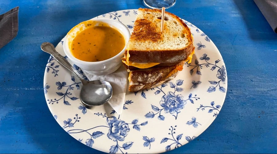 Grilled cheese with tomato basil & cream soup in a blue floral plate at Blue Door Farmstand