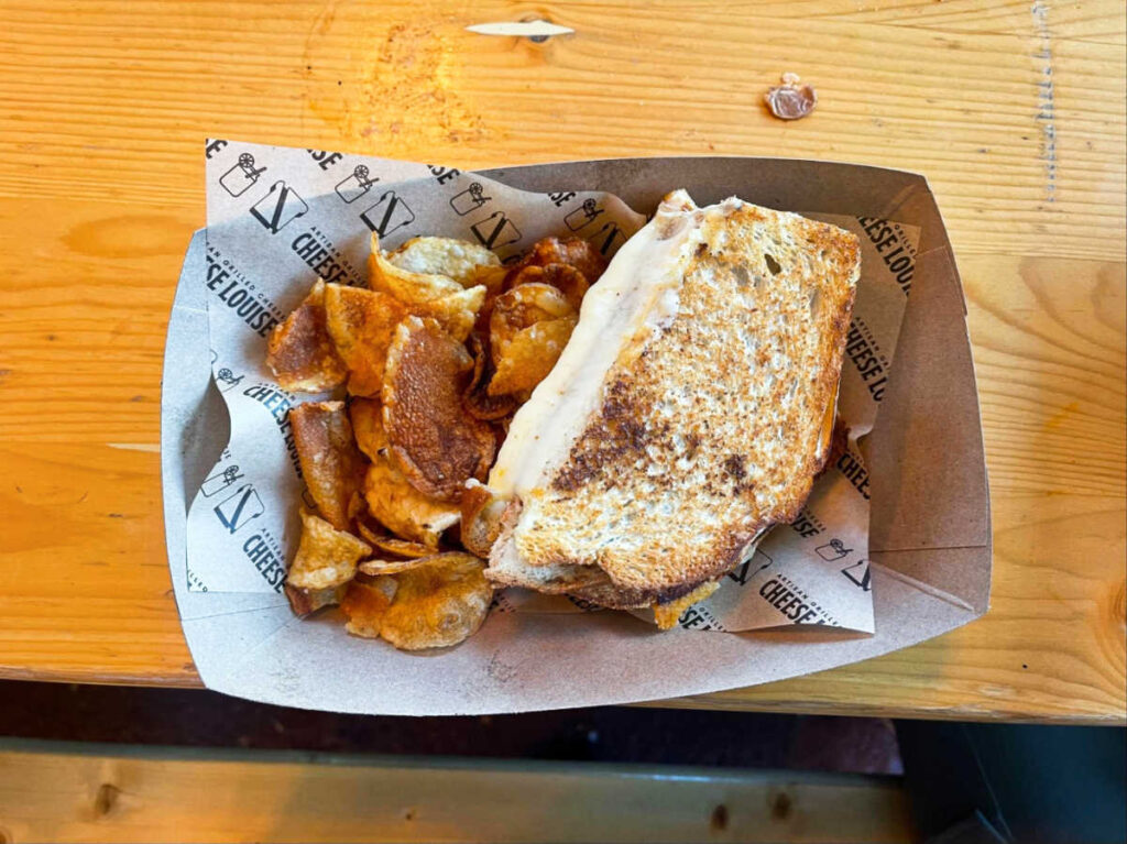 Grilled cheese and chips on a disposable plate