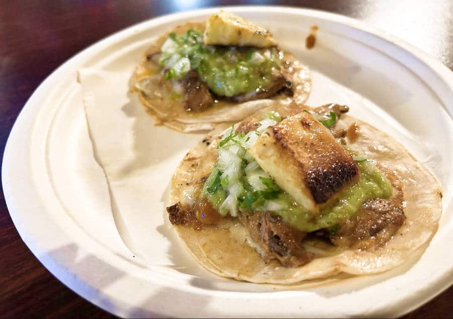 A plate of two grilled pineapple on tacos in Tacos Chukis