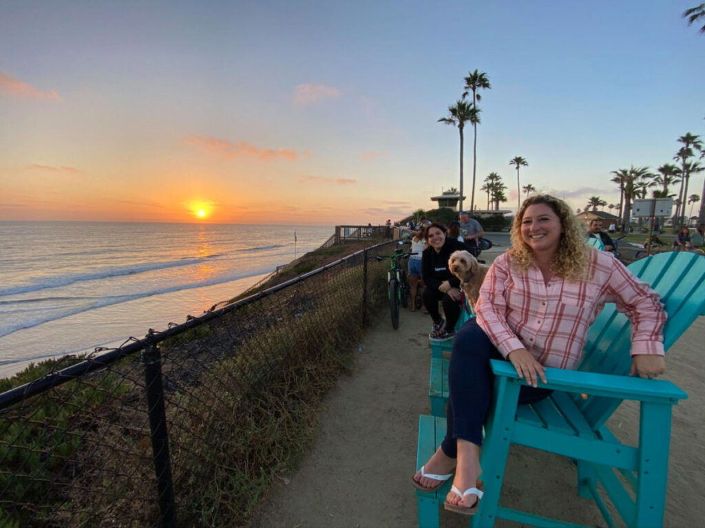 Author Jess with her dates sitting on a chair and watching the sunset at The Camp Store