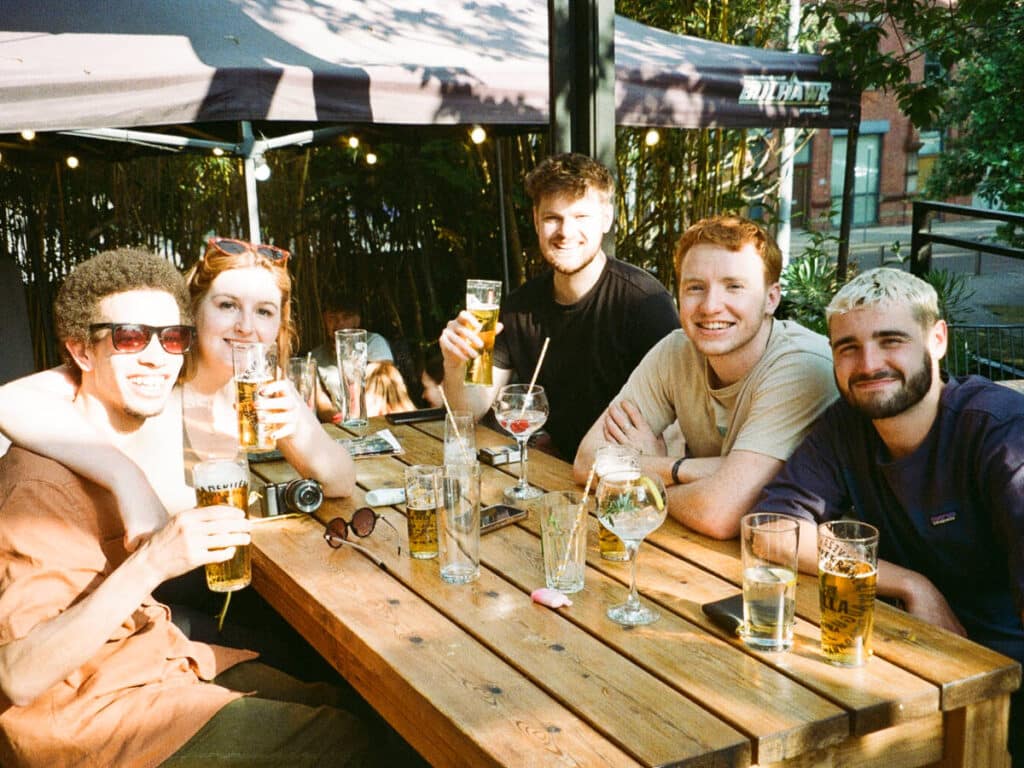 A group of friends drinking and chilling at an outdoor patio of a bar