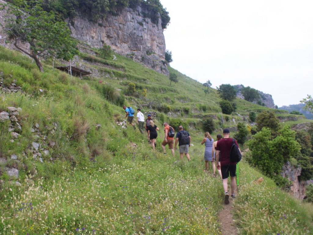 Tour group members hiking up a steep hill