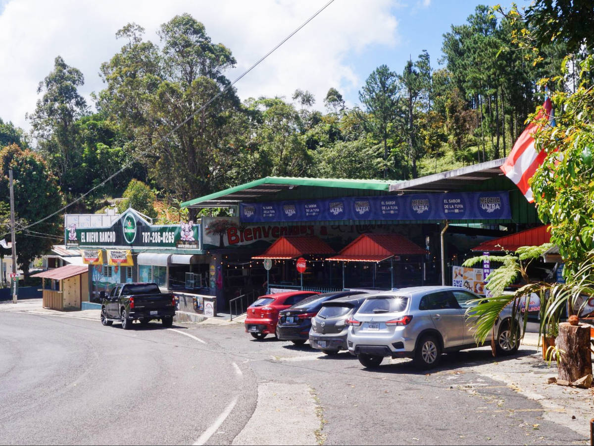 Cars parked on the side of a road in Guavate
