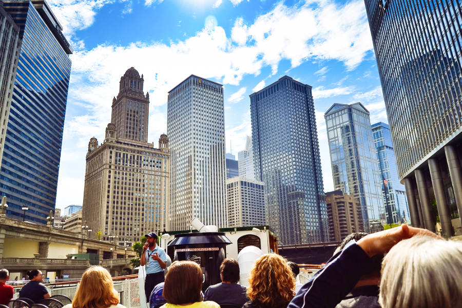 View of the tourists and the guide o the boat with the Chicago skyscrapers in the background
