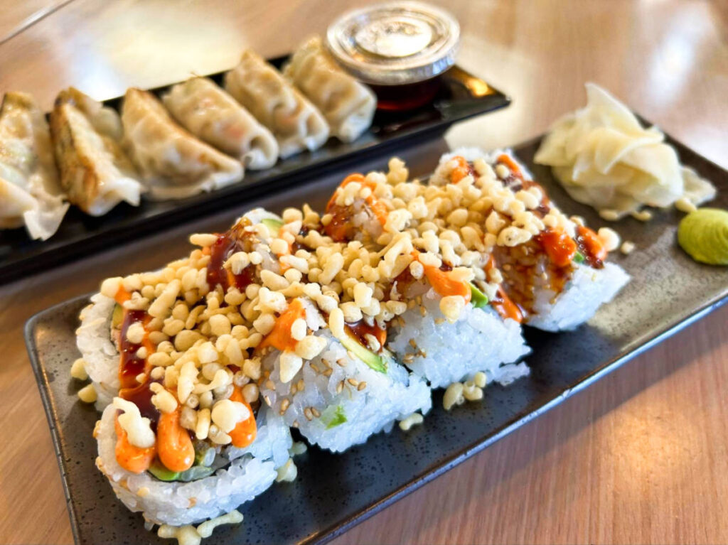 Plates of gyoza and tempura roll from Wellness Sushi