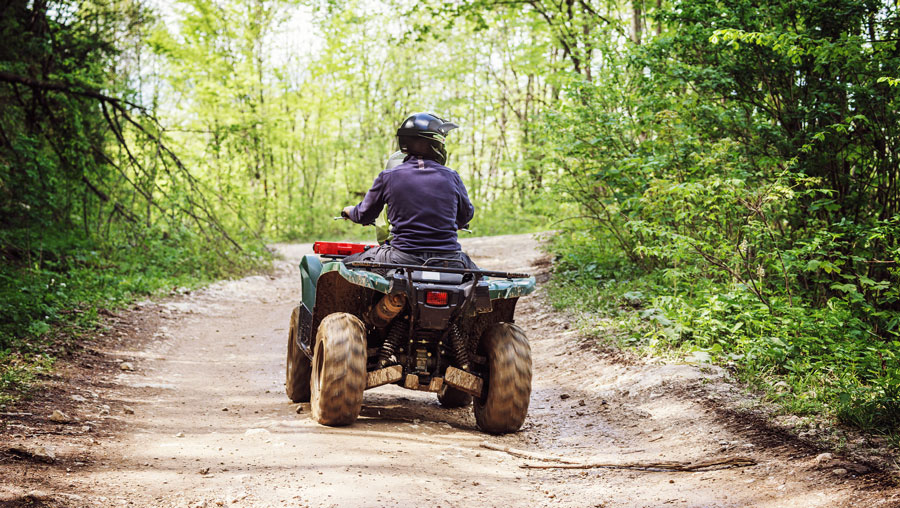 View of a man riding an ATV in the mountain road