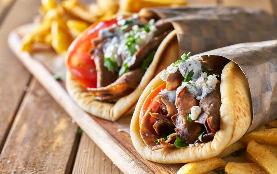 Gyros and fries on a wooden board in Haji Baba