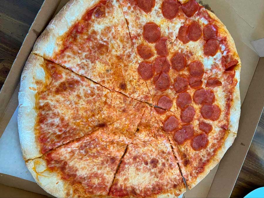 View of a half pepperoni and half cheese flavored pizza on a box
