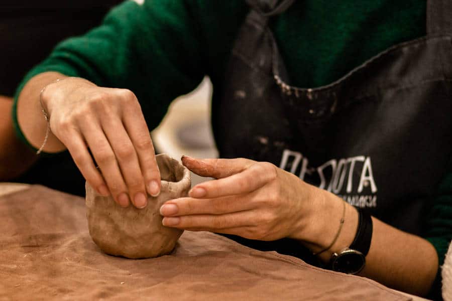 Close up look of the hands molding clay