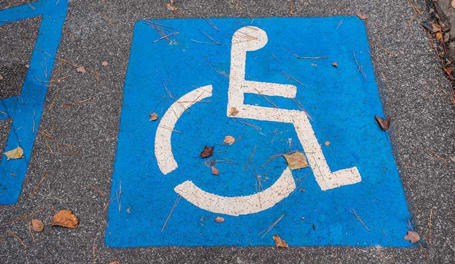 A handicap symbol signage painted on the parking lot's ground