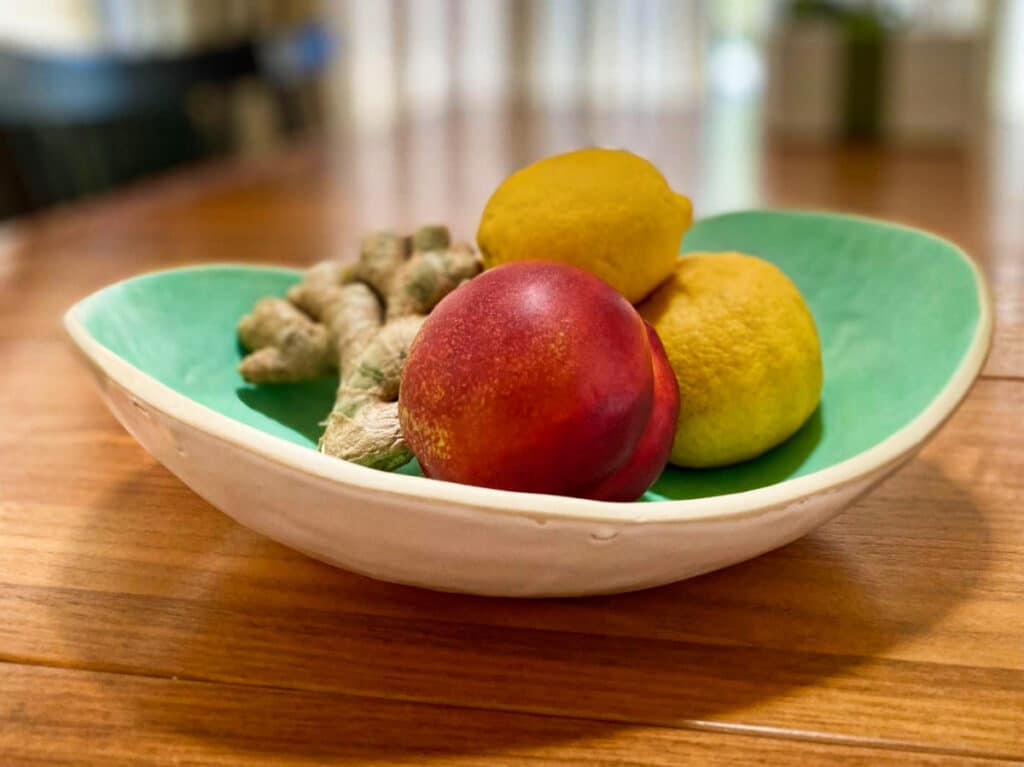 A variety of fruits and vegetables on a handmade dish plate