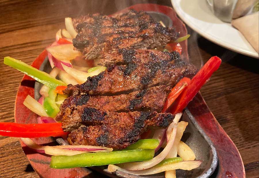 A sizzling steak with vegetables on a sizzling plate served in Hard Rock Cafe