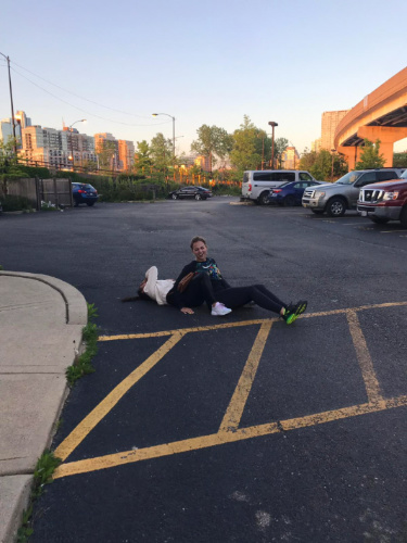 Two woman lying on the ground in a parking lot