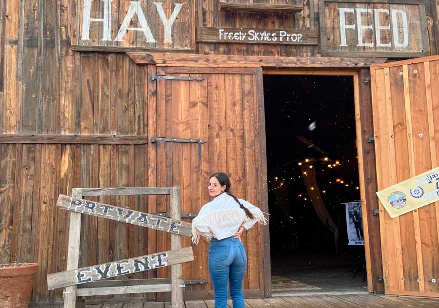 The author posing for a photo at the entrance of Hay Feed in Pioneertown