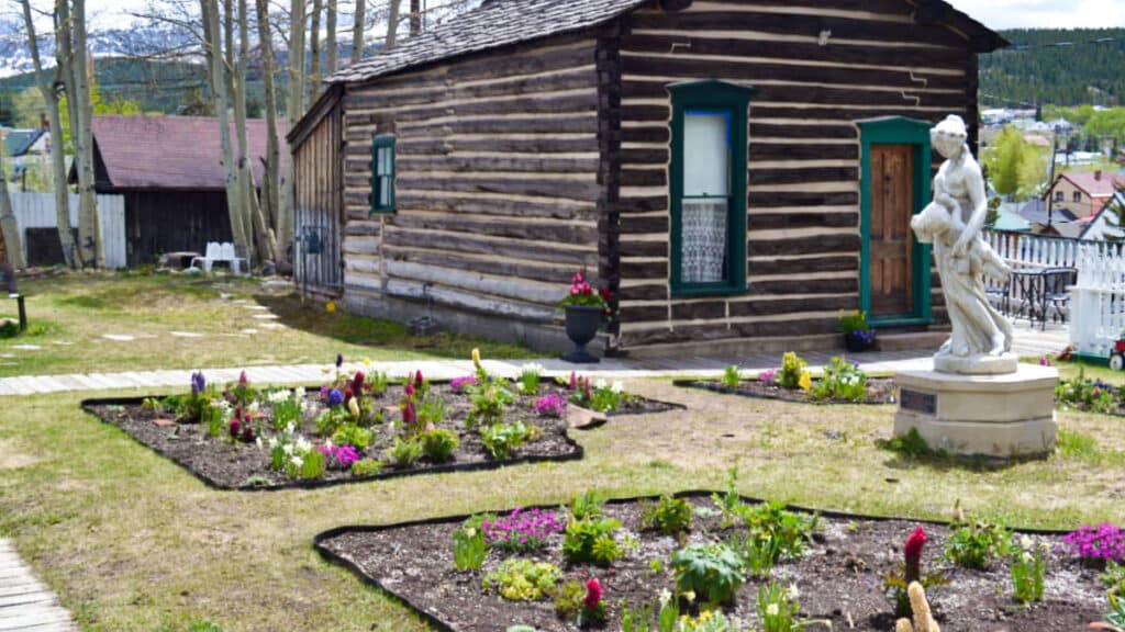 View of the garden landscape with a statue near the cabin at Healy House Museum & Dexter Cabin