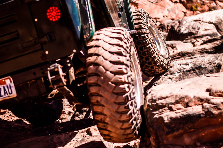 Closeup view of the wheels of a 4x4 car at an off-roading trail