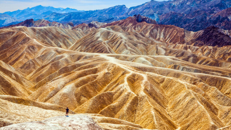 Aerial view of a hiker admiring the erosion landscape at the Zabriskie Point
