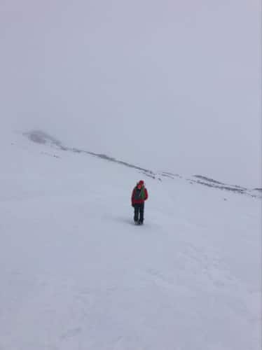 A hiker walking along the snow covered Mt. Hood
