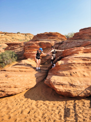 Two hikers helping each other at the Red Rocks