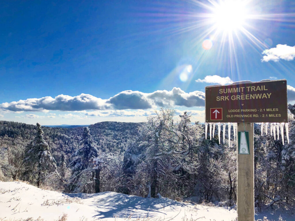 View of the hiking trail signage at Mount Sunapee on a sunny winter day