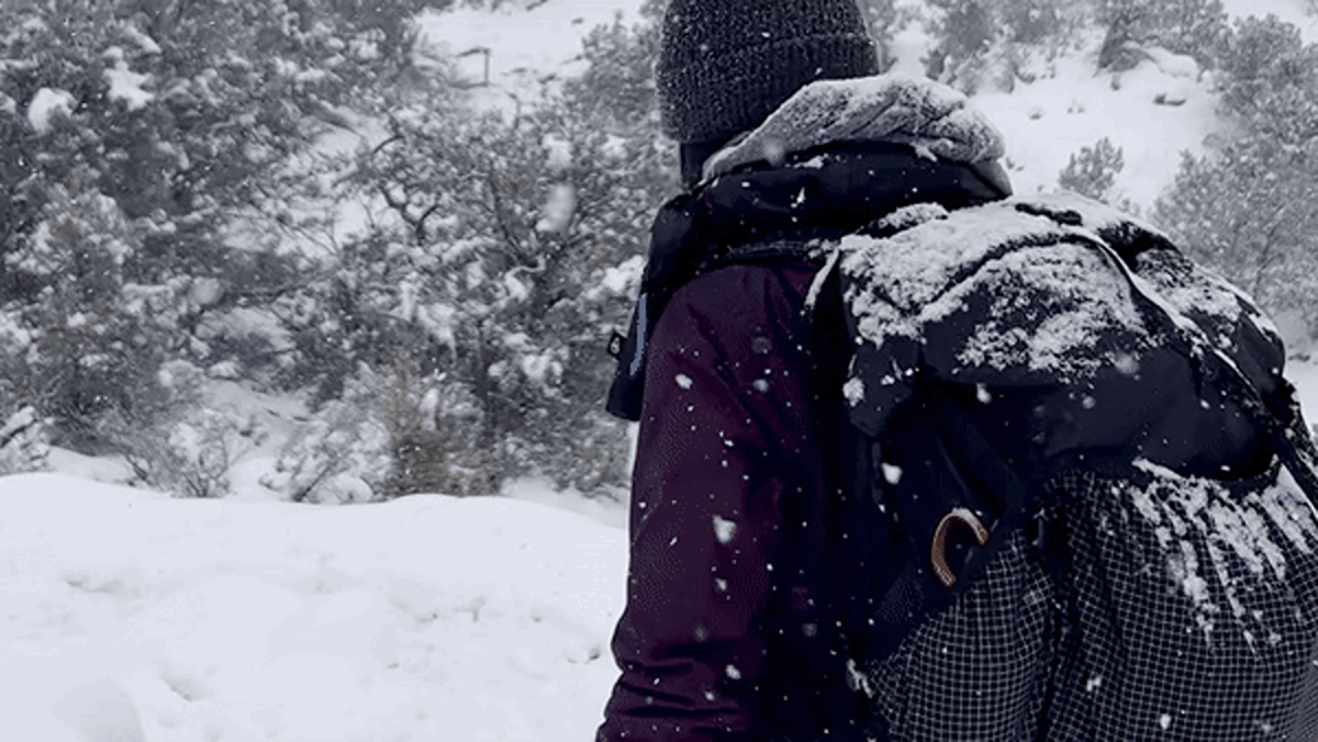 The author, Abigail, walking under the heavy snow while carrying the Hyperlite Mountain Gear Southwest Backpack