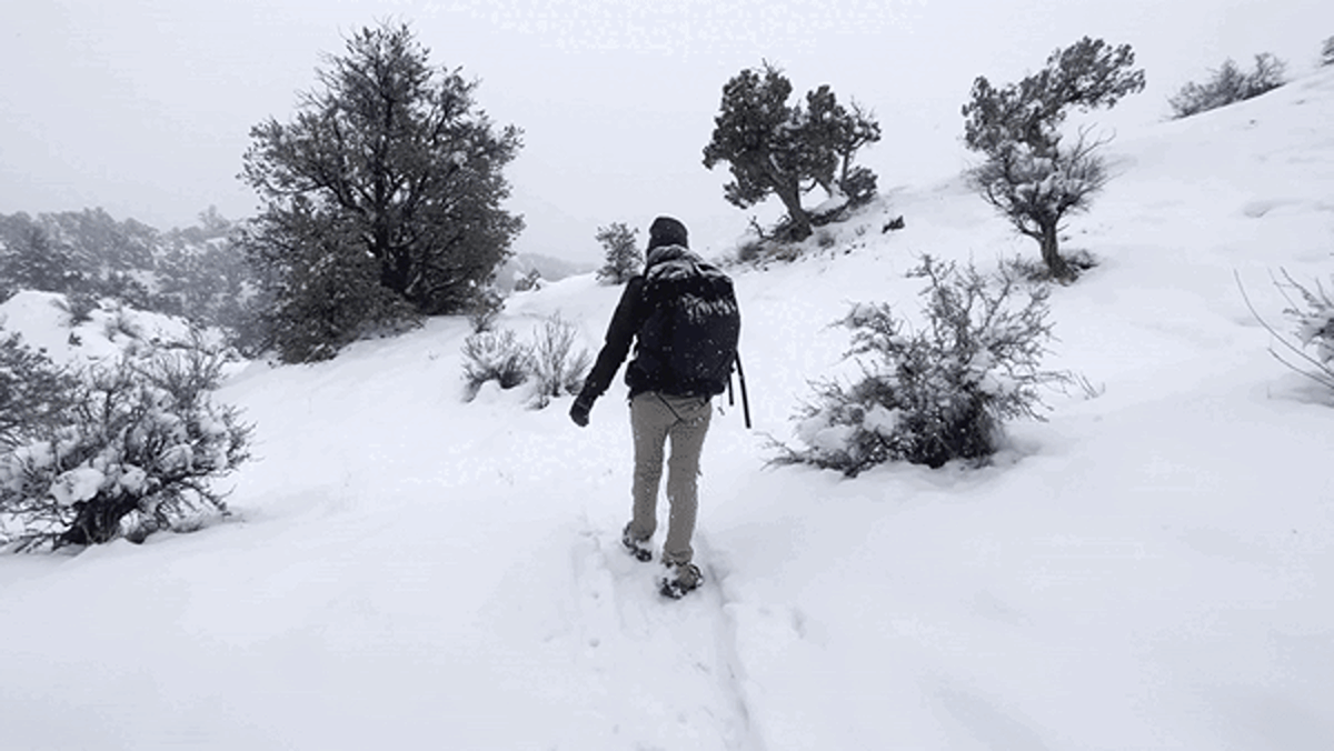 The author, Abigail, walking under the heavy snow while carrying the Hyperlite Mountain Gear Southwest Backpack