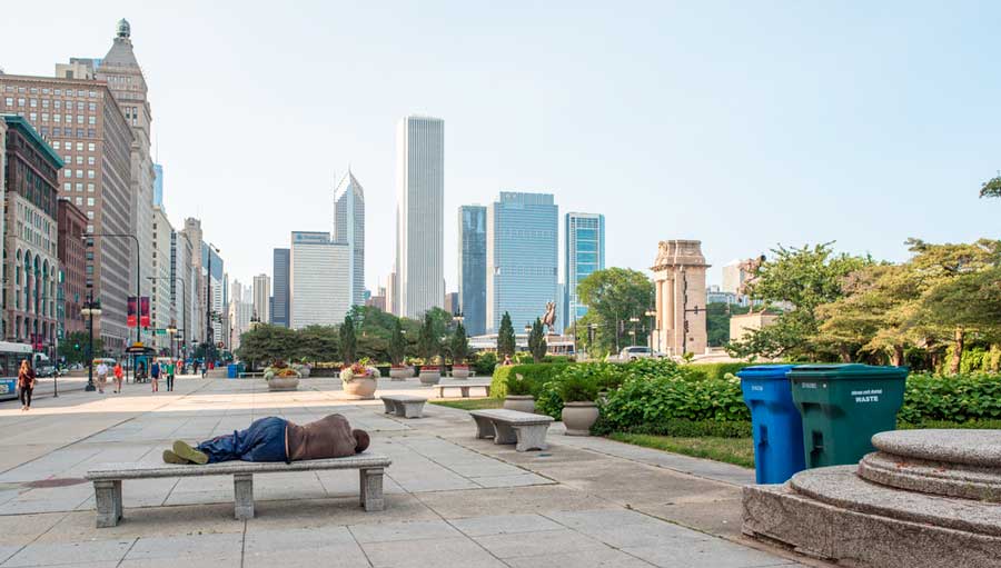A homeless man sleeping on a public bench