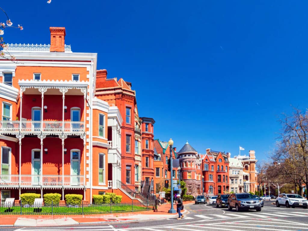 View of the beautiful row houses surrounded with greenery in the neighborhood of Logan Circle with a clear blue sky in the background