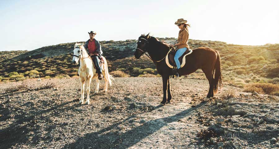 A man and a woman riding a horse