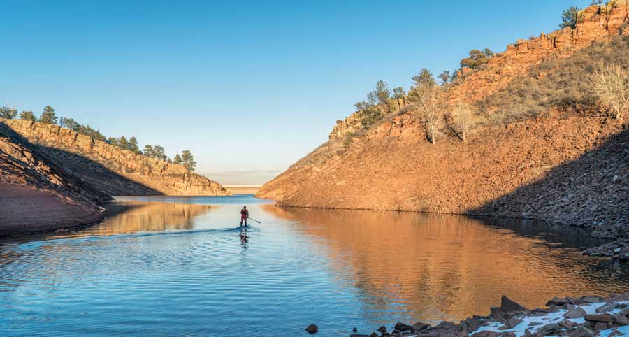 A man paddleboarding in Horsetooth Reservoir