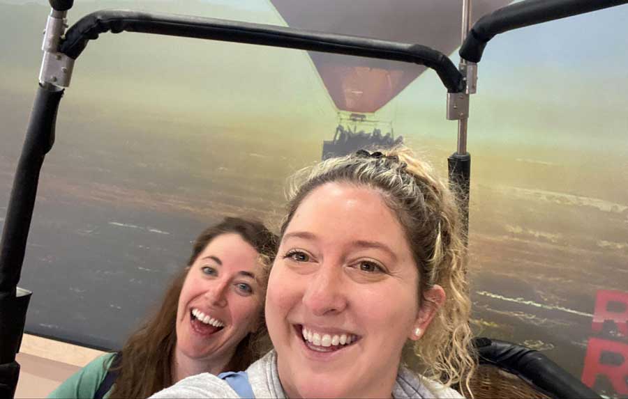 The author with a friend smiling for a selfie while riding a hot air balloon