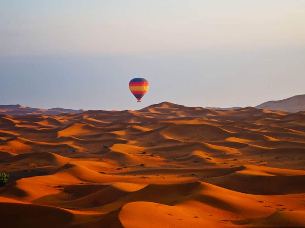 A hot air balloon over the sand dunes in Dubai at sunset