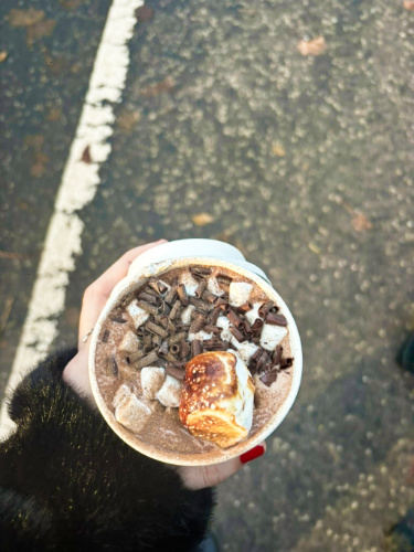 A hand holding a cup of hot chocolate from Uplands Roast