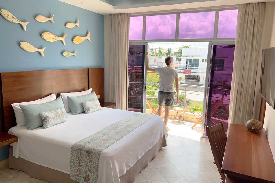 Nate admiring the view from the balcony of their room in Hotel Biwa Tulum