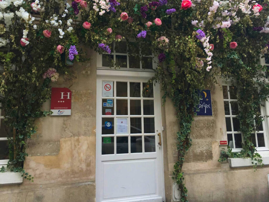 A charming hotel entryway with colorful flowers above