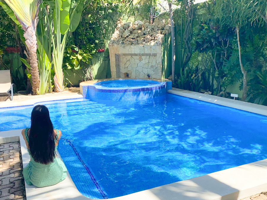 Clara sitting on the edge of the pool in Hotel Luna Sol Outdoor Pool